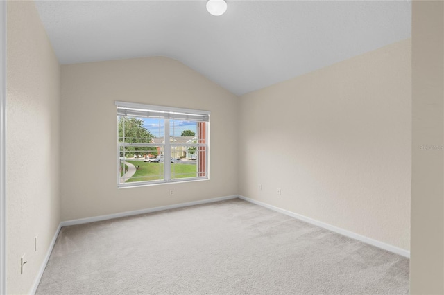 carpeted empty room with lofted ceiling