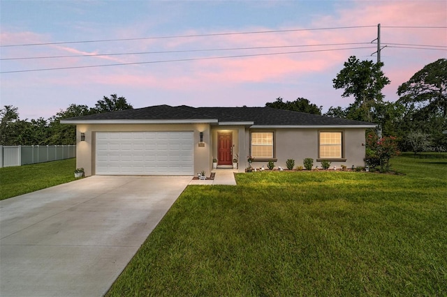 ranch-style house featuring a garage and a lawn