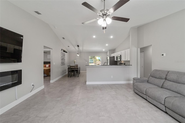 living room featuring ceiling fan, sink, and lofted ceiling