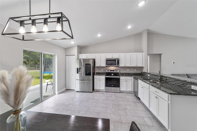 kitchen featuring dark stone counters, sink, white cabinets, decorative light fixtures, and stainless steel appliances