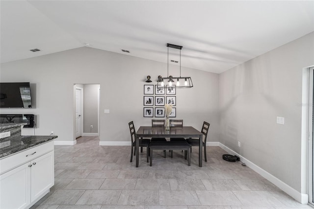 dining area with a notable chandelier and lofted ceiling