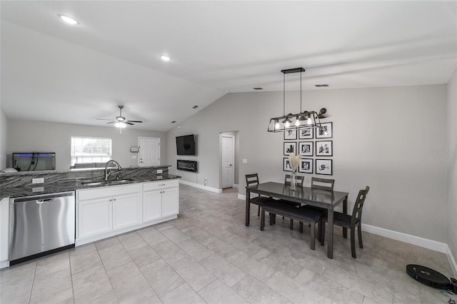 kitchen featuring dishwasher, white cabinetry, sink, dark stone countertops, and pendant lighting