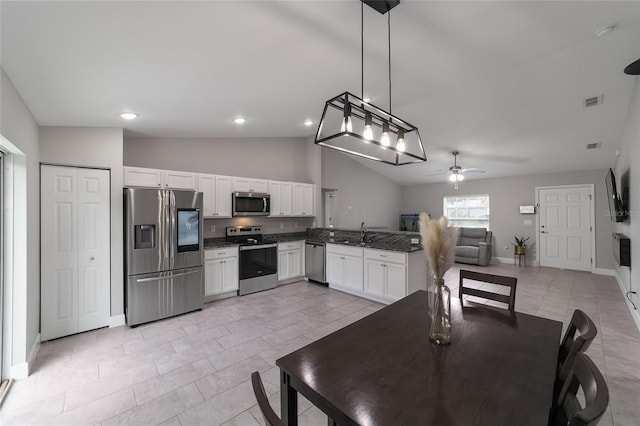 dining space with ceiling fan, sink, light tile patterned flooring, and vaulted ceiling