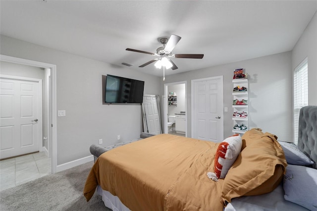 bedroom with ceiling fan, light tile patterned floors, and ensuite bath