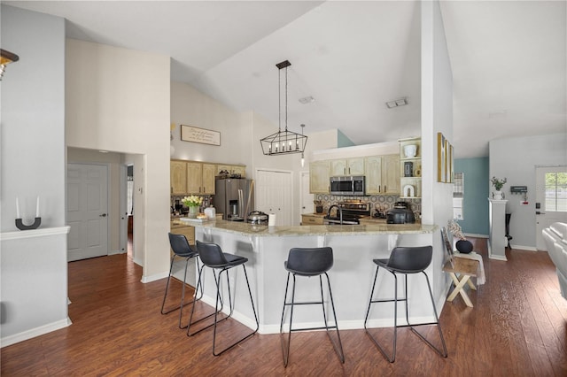 kitchen with lofted ceiling, dark hardwood / wood-style floors, kitchen peninsula, stainless steel appliances, and decorative backsplash