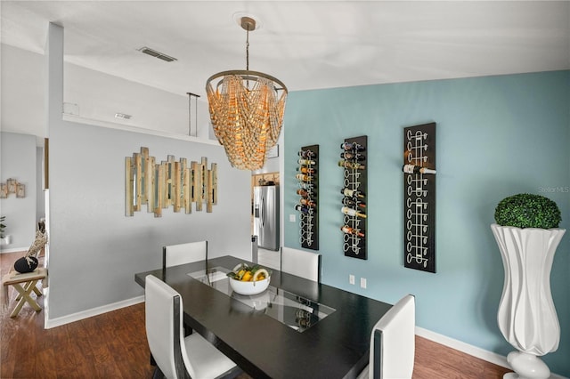 dining space with dark hardwood / wood-style floors and an inviting chandelier