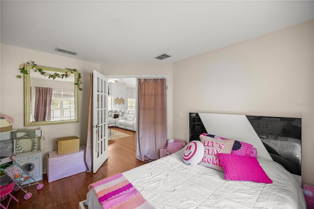 bedroom with hardwood / wood-style flooring and french doors