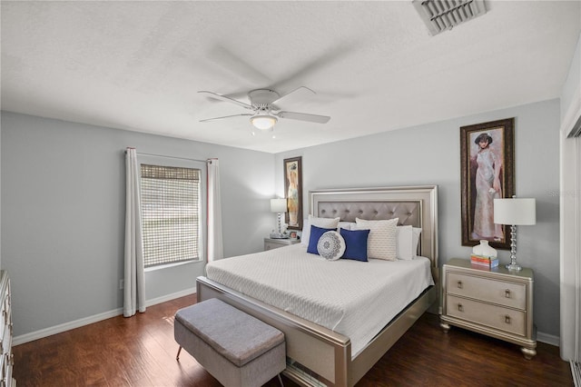 bedroom with ceiling fan, dark hardwood / wood-style flooring, and a textured ceiling