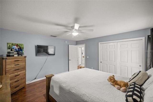 bedroom with dark hardwood / wood-style flooring, a closet, and ceiling fan