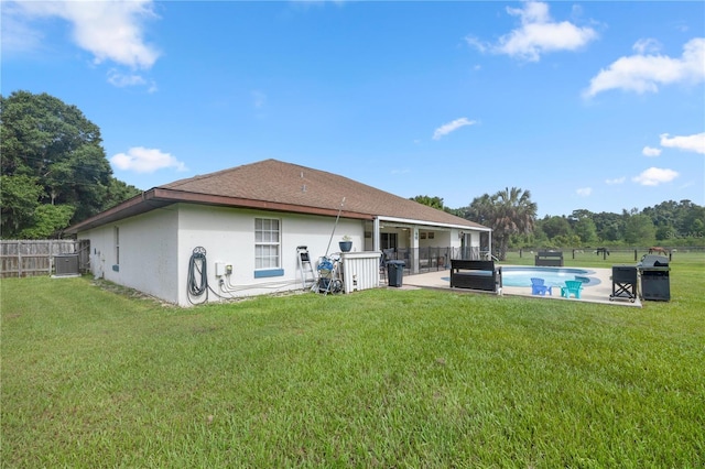 back of property with cooling unit, a yard, a fenced in pool, and a patio area