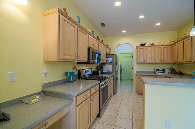 kitchen with light brown cabinetry, appliances with stainless steel finishes, and light tile patterned floors