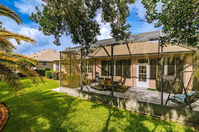 back of house featuring a patio, a yard, and glass enclosure