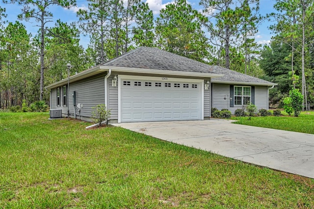 view of front of house featuring a garage, central AC unit, and a front yard