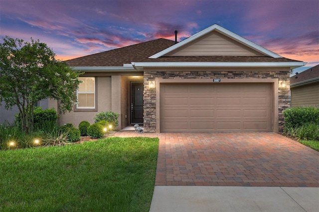 view of front of property featuring a garage and a lawn