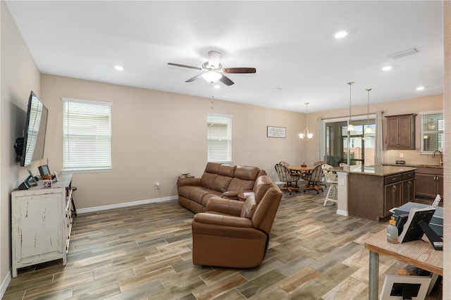 living room featuring sink, ceiling fan, and plenty of natural light