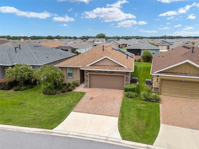 single story home featuring central air condition unit, a front yard, and a garage