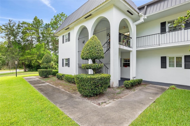 doorway to property featuring a yard and a balcony