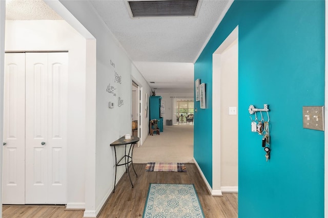 corridor featuring wood-type flooring and a textured ceiling