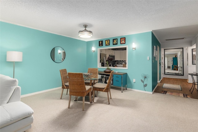 carpeted dining space featuring a textured ceiling