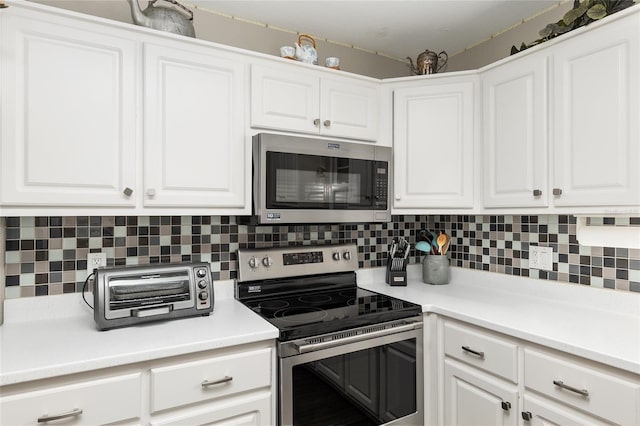 kitchen with stainless steel appliances, tasteful backsplash, and white cabinets