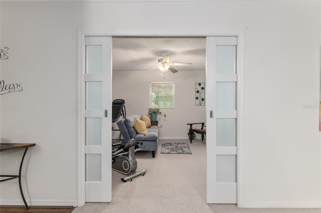 interior space with ceiling fan, carpet flooring, and a textured ceiling