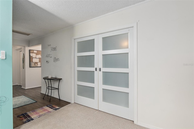 hall with a textured ceiling and carpet flooring