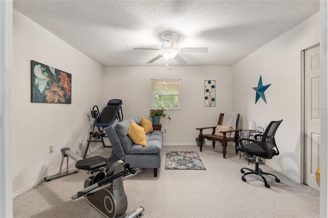 exercise area with ceiling fan and a textured ceiling