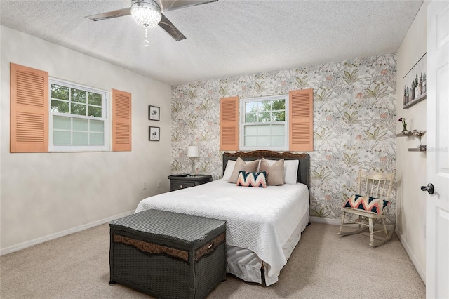 bedroom featuring multiple windows, carpet floors, a textured ceiling, and ceiling fan