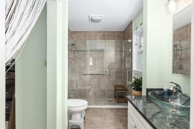 bathroom with vanity, toilet, tile patterned flooring, and a shower with door