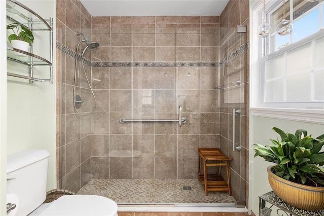 bathroom with toilet and a tile shower