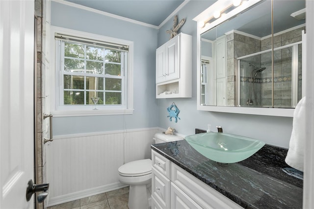 bathroom with a shower with shower door, vanity, ornamental molding, toilet, and tile patterned floors