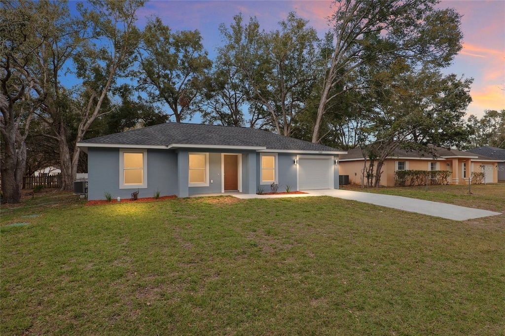 ranch-style home with a garage and a yard