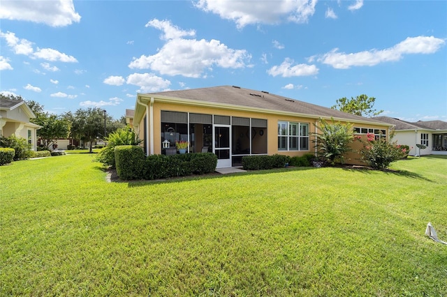 back of property with a sunroom and a yard