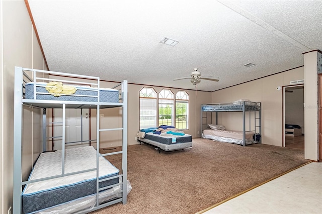 carpeted bedroom with a ceiling fan, a textured ceiling, visible vents, and crown molding