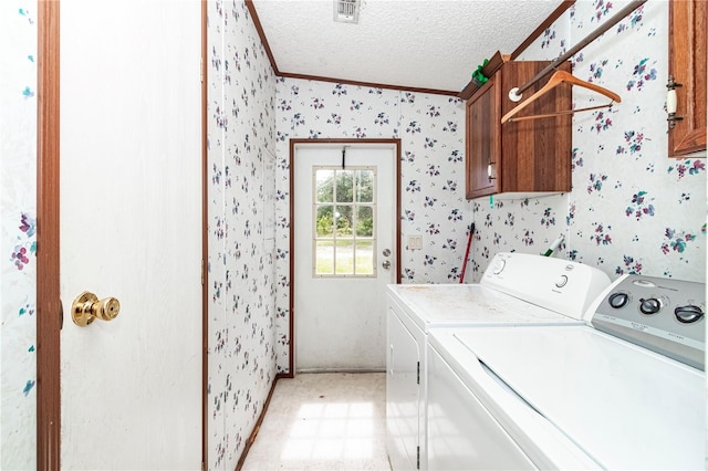 clothes washing area with cabinets, crown molding, a textured ceiling, and independent washer and dryer