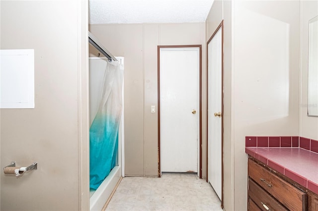 bathroom featuring a textured ceiling and a shower with curtain