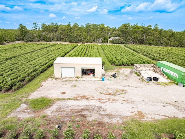 exterior space with a garage, an outbuilding, a pole building, and a rural view