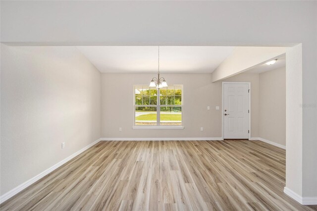 interior space with lofted ceiling, light hardwood / wood-style flooring, and an inviting chandelier