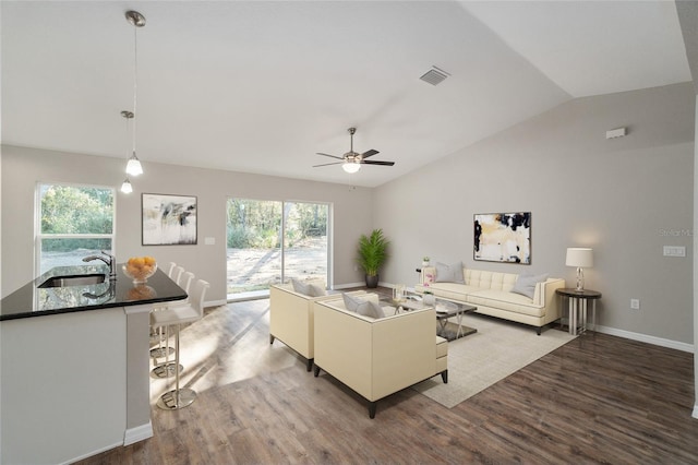 living room featuring ceiling fan, sink, hardwood / wood-style flooring, and vaulted ceiling