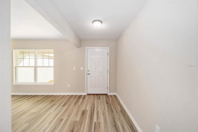 entryway with light hardwood / wood-style floors and beamed ceiling