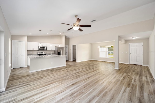 unfurnished living room with light hardwood / wood-style floors, ceiling fan, and high vaulted ceiling