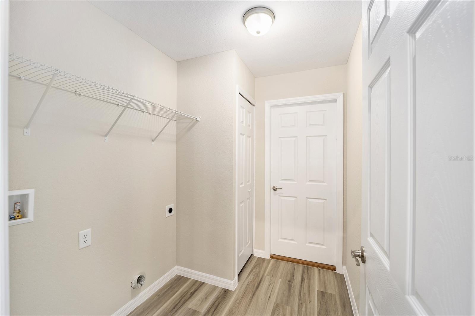 clothes washing area with electric dryer hookup, light wood-type flooring, and washer hookup