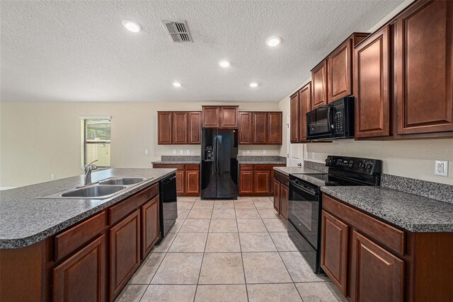 kitchen featuring sink, a textured ceiling, black appliances, and light tile patterned floors