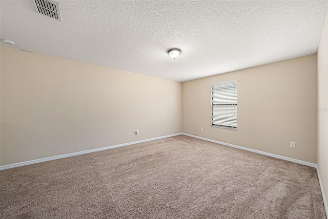 spare room featuring carpet and a textured ceiling