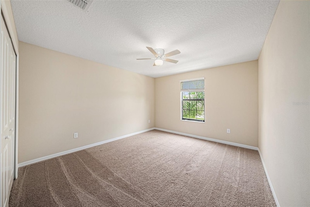 unfurnished room with carpet flooring, a textured ceiling, and ceiling fan