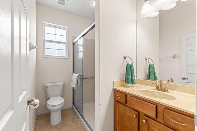 bathroom featuring vanity, tile patterned floors, toilet, and walk in shower