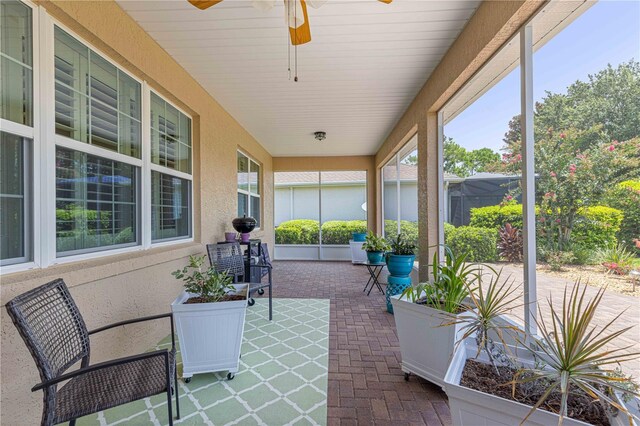 sunroom featuring ceiling fan