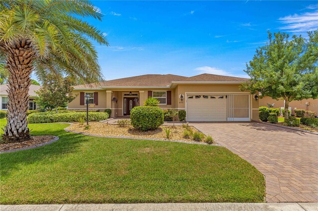 ranch-style home featuring a garage and a front lawn