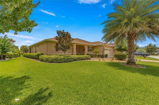 single story home featuring a garage and a front lawn