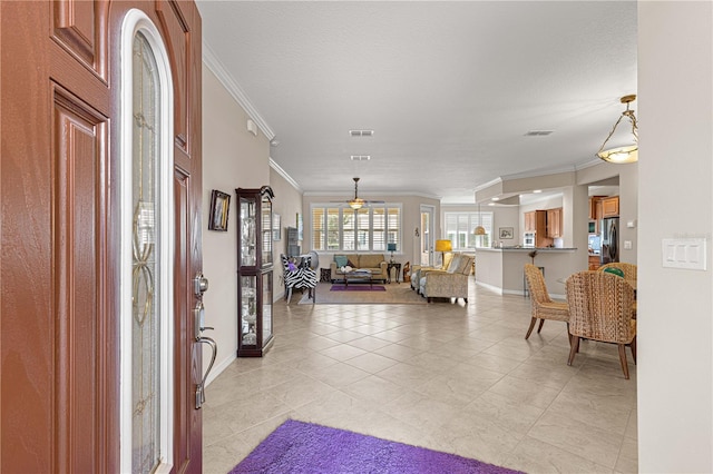 tiled entrance foyer featuring ceiling fan and ornamental molding